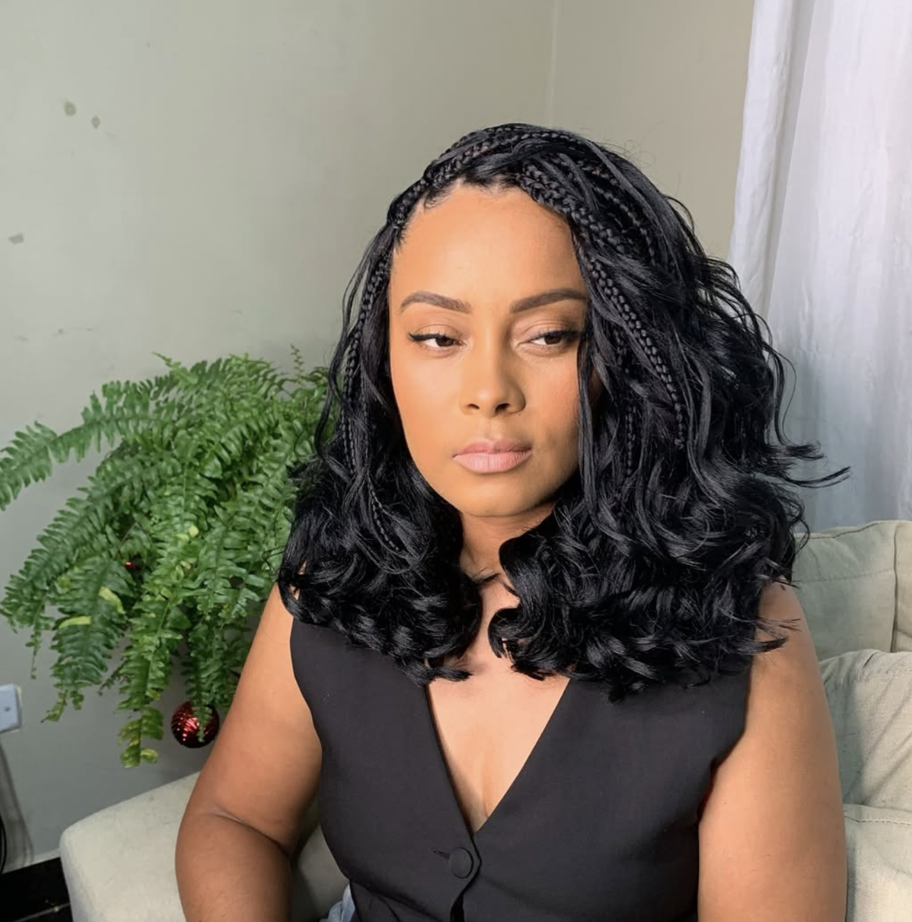French curl braids with long curled ends worn in a polished ponytail