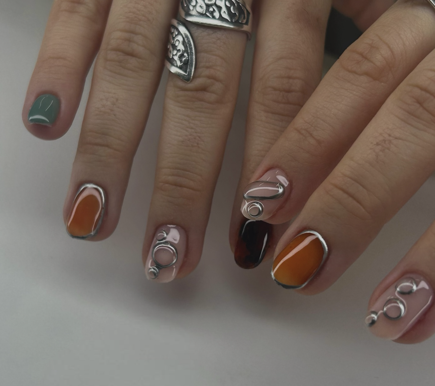Short squoval nails with a diffused rust-colored aura.