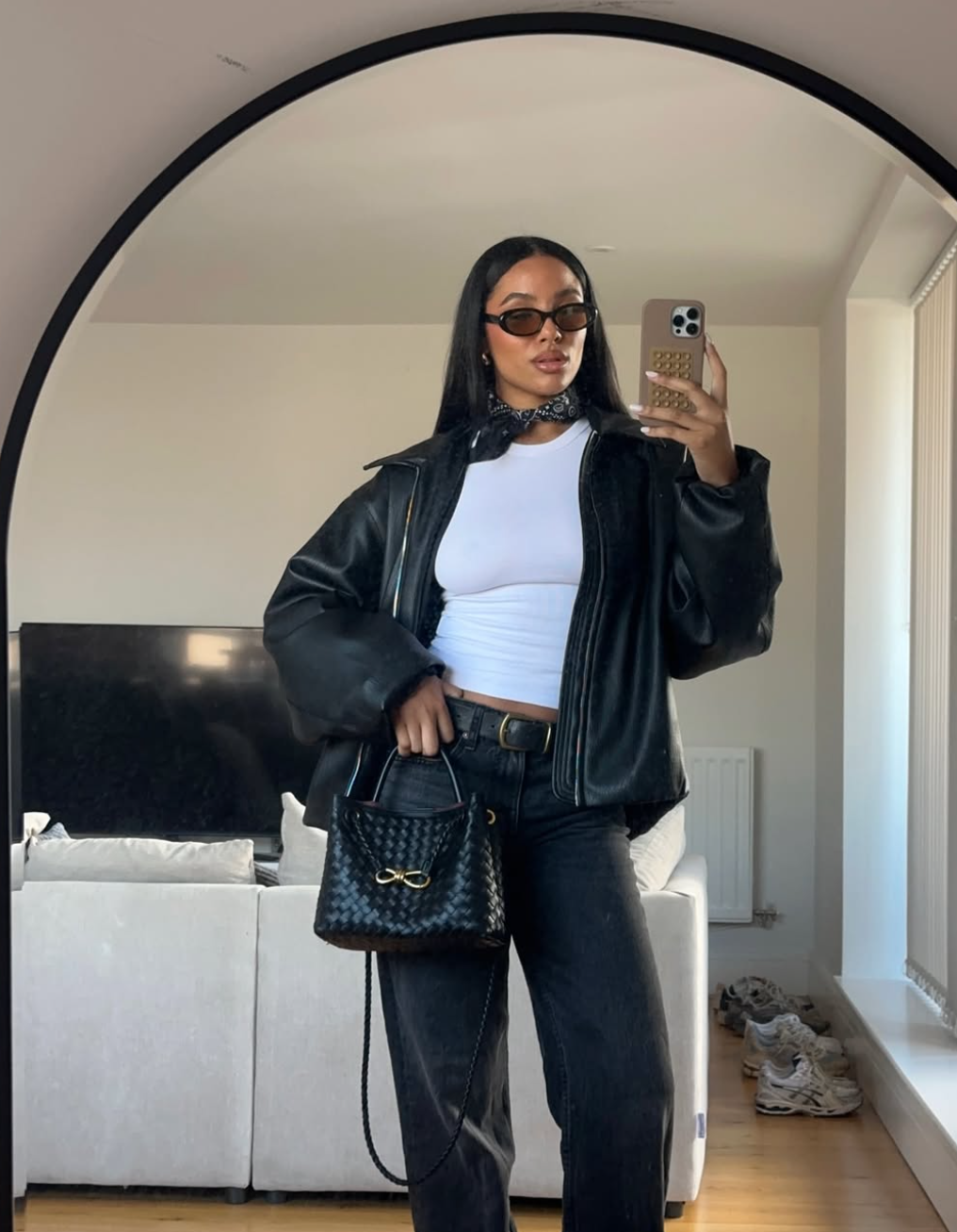 woman taking a selfie  wearing aleather jacket, white tshirt and black jeans