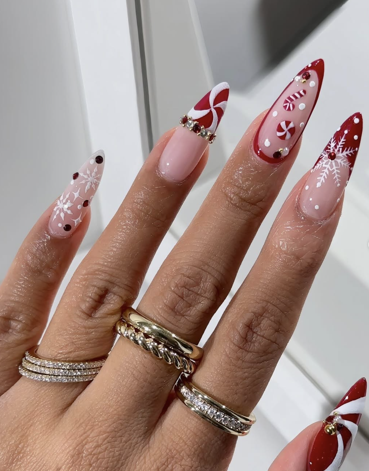 Red and white peppermint swirl nail art with glossy red Christmas nails