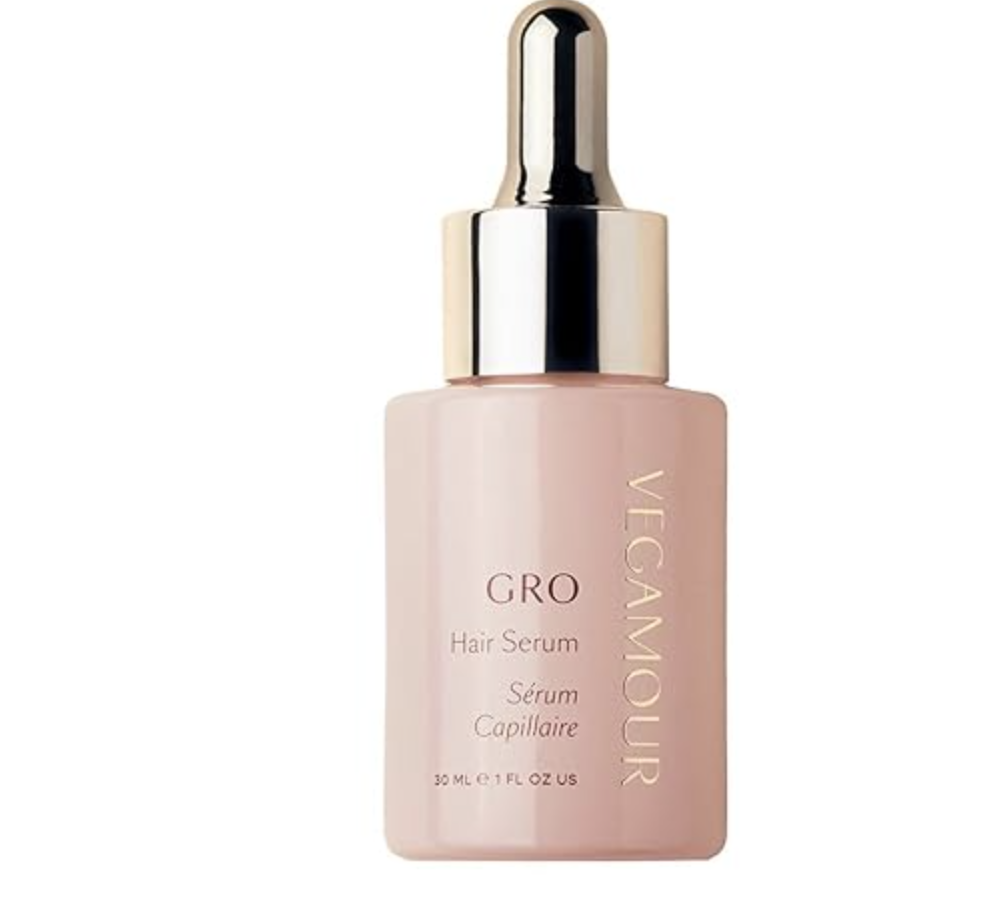 A frosted glass dropper bottle of Vegamour GRO Hair Serum with a silver cap and a peach-colored label, designed for hair thinning and shedding.