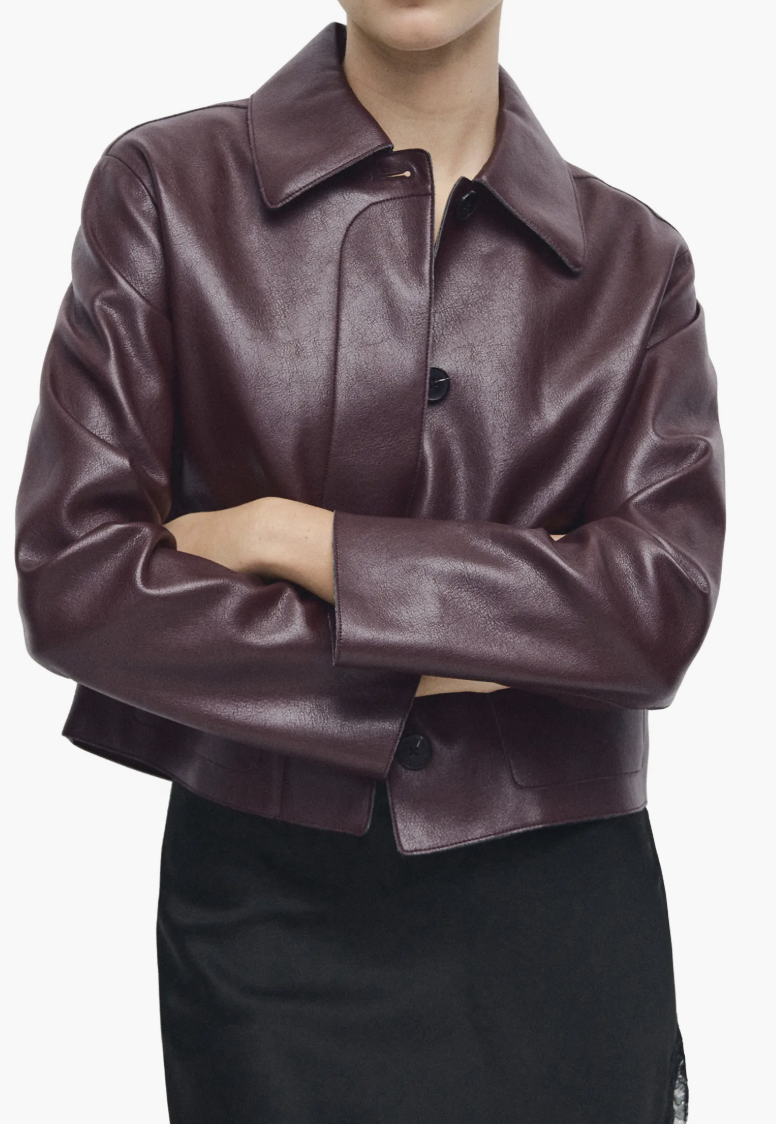 Front view of a model wearing high-waisted eggplant purple stirrup leggings from Naked Wardrobe with a matching long-sleeve top.