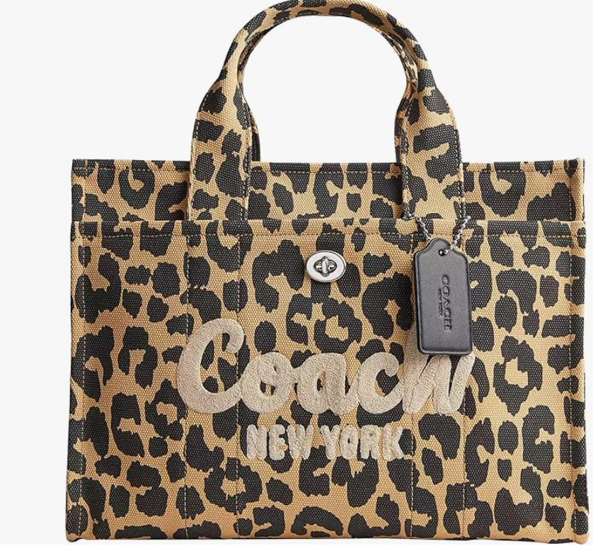 A Coach Women's Cargo Tote in a bold leopard print, shown as a structured and stylish laptop-friendly bag for a professional capsule wardrobe.