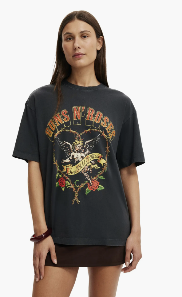 A close-up of a charcoal grey vintage-style Guns N' Roses graphic t-shirt featuring the iconic Sweet Child O' Mine emblem with roses and angel wings.