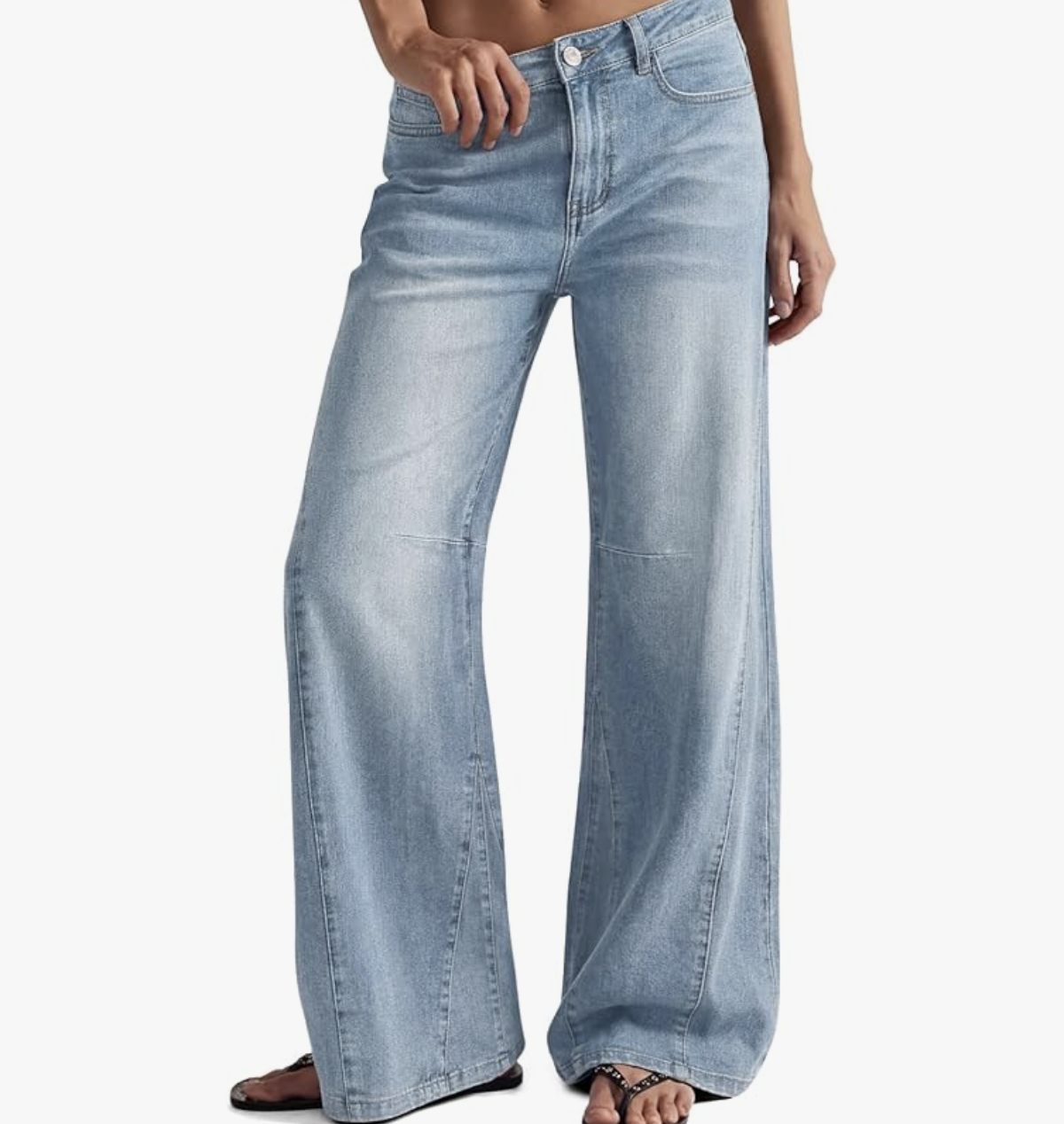A close-up of a person wearing relaxed, light-wash wide-leg baggy denim jeans with front seam details.