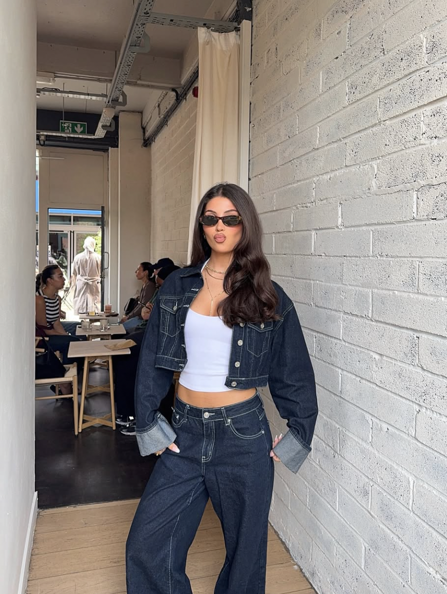 A fashion editor-approved look featuring a dark wash double denim set with wide-leg jeans and a cropped jacket, paired with platform sandals to balance the proportions, styled by @lydiakarax.