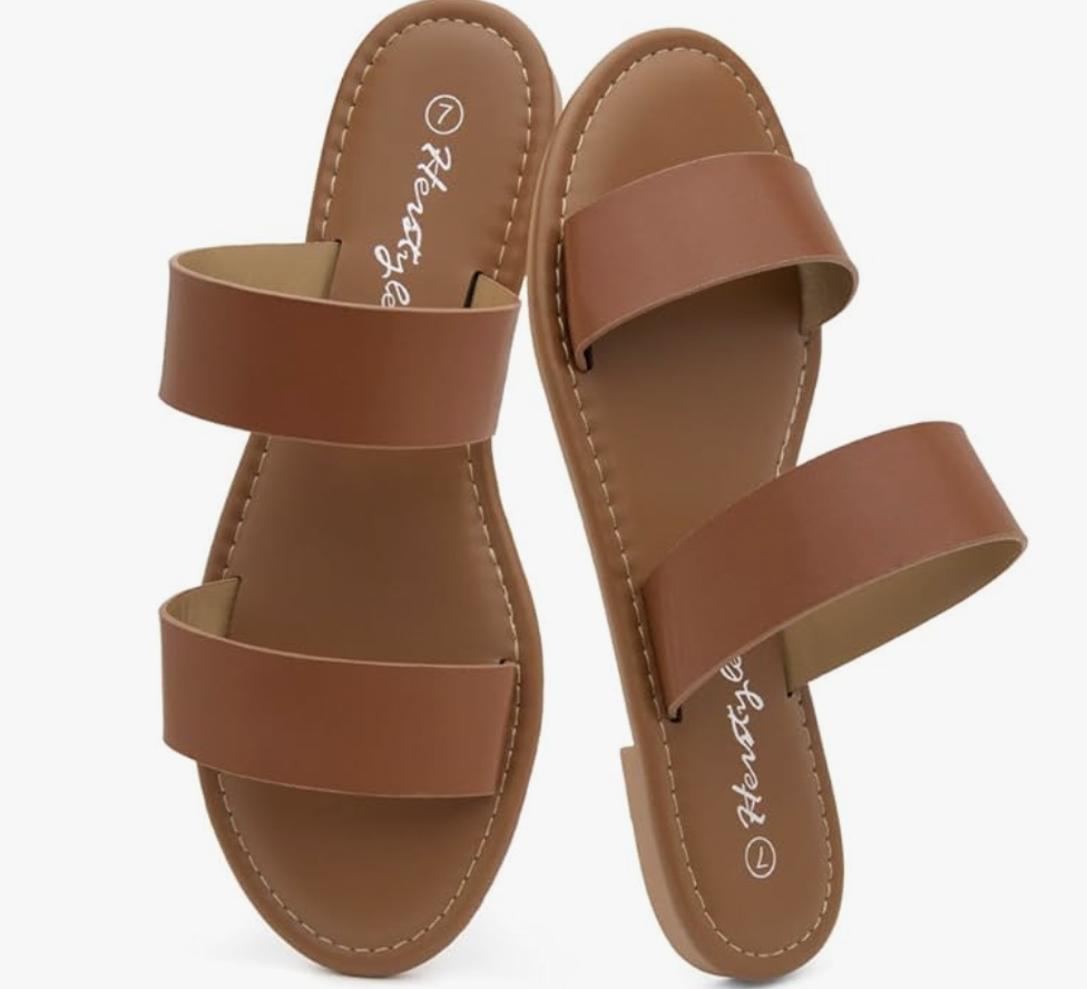 A pair of brown leather slip-on two-strap slides, shown as a footwear option for what to wear with a spaghetti strap dress.