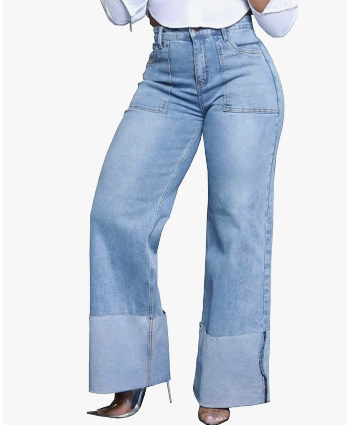 A close-up of a woman wearing light-wash, high-waisted wide-leg denim jeans featuring prominent wide cuffs at the hem and front patch pockets.