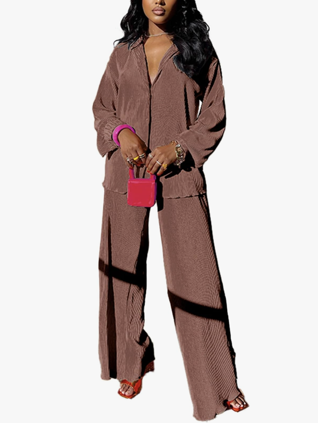 A woman wearing a chocolate brown long sleeve button-down shirt and matching flare pleated wide-leg pants, styled as a sophisticated and comfortable dinner outfit for a cruise.