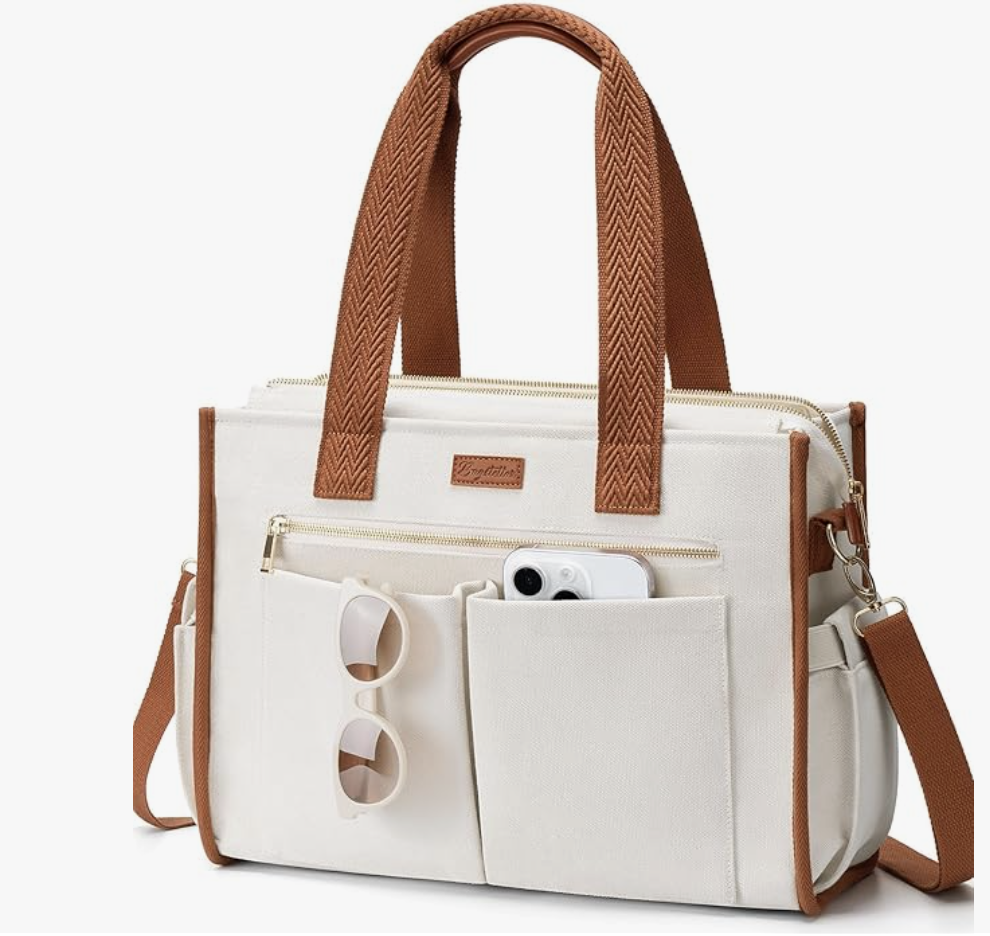 Cream canvas laptop tote bag with brown chevron-patterned straps, featuring multiple exterior pockets containing a smartphone and sunglasses.