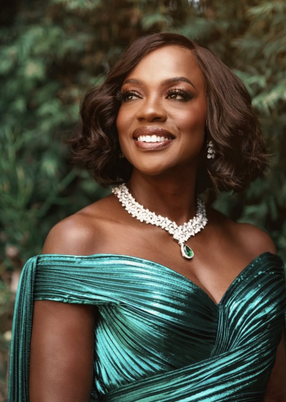 Viola Davis wearing a shimmering emerald green pleated gown and a statement diamond necklace, illustrating how rich, jewel-toned colors with warm-depth harmonize with the True Autumn season.