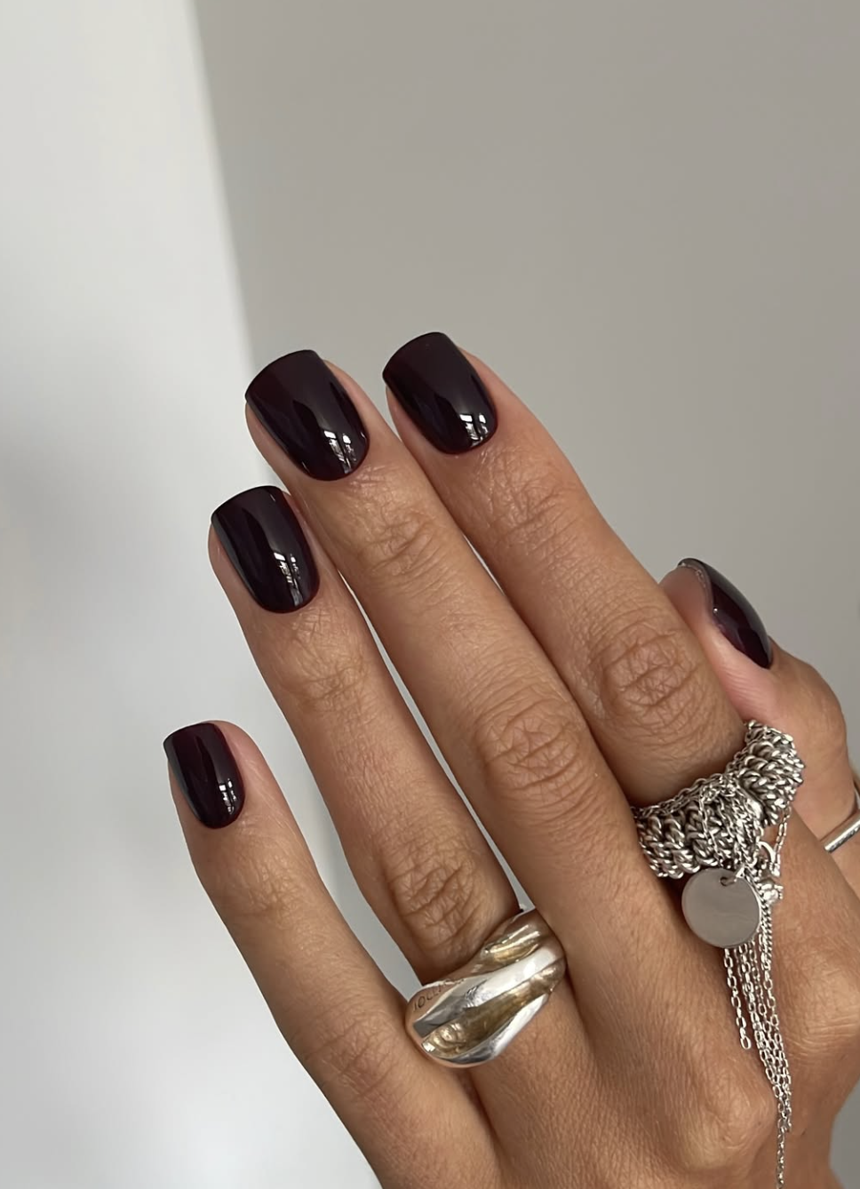Dark fig and blackberry-plum manicure on medium oval nails.