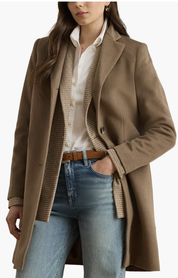 Woman over 60 wearing a truffle longline wool-blend coat over a navy knit dress.