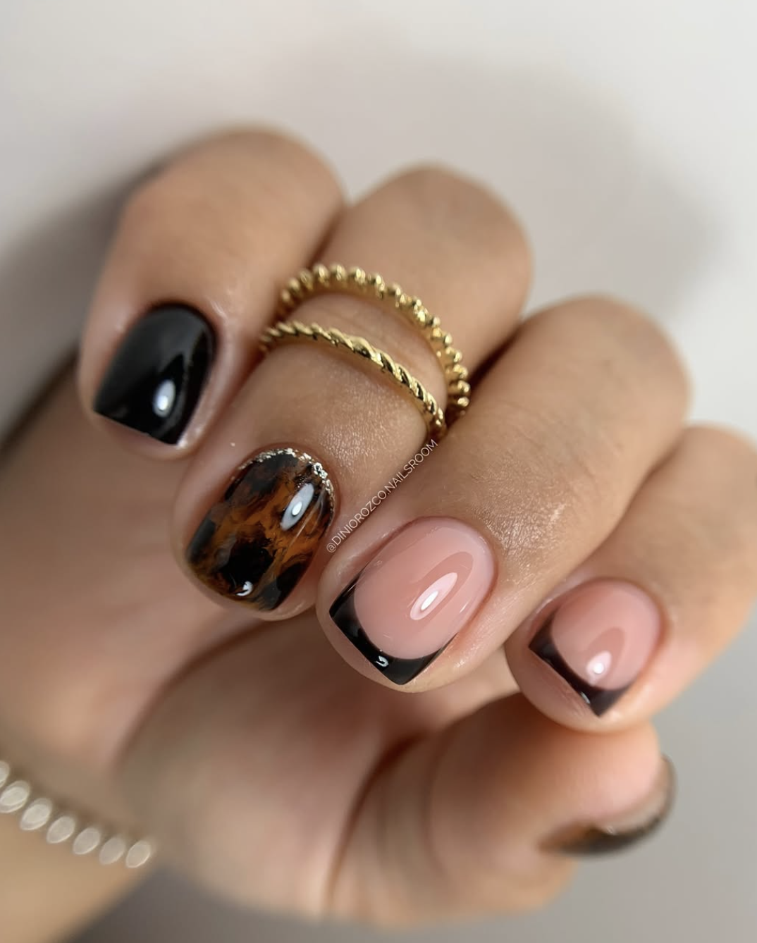 Sheer short nails with one amber-and-brown tortoiseshell accent nail.