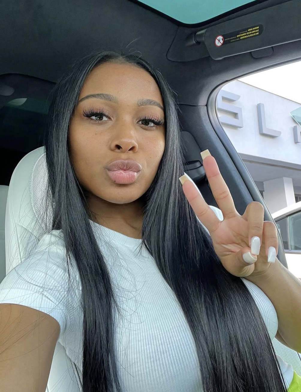 Jayda Cheaves featuring a sleek sew-in with long, straight black hair and a clean side part, showcasing a polished and glamorous protective style.