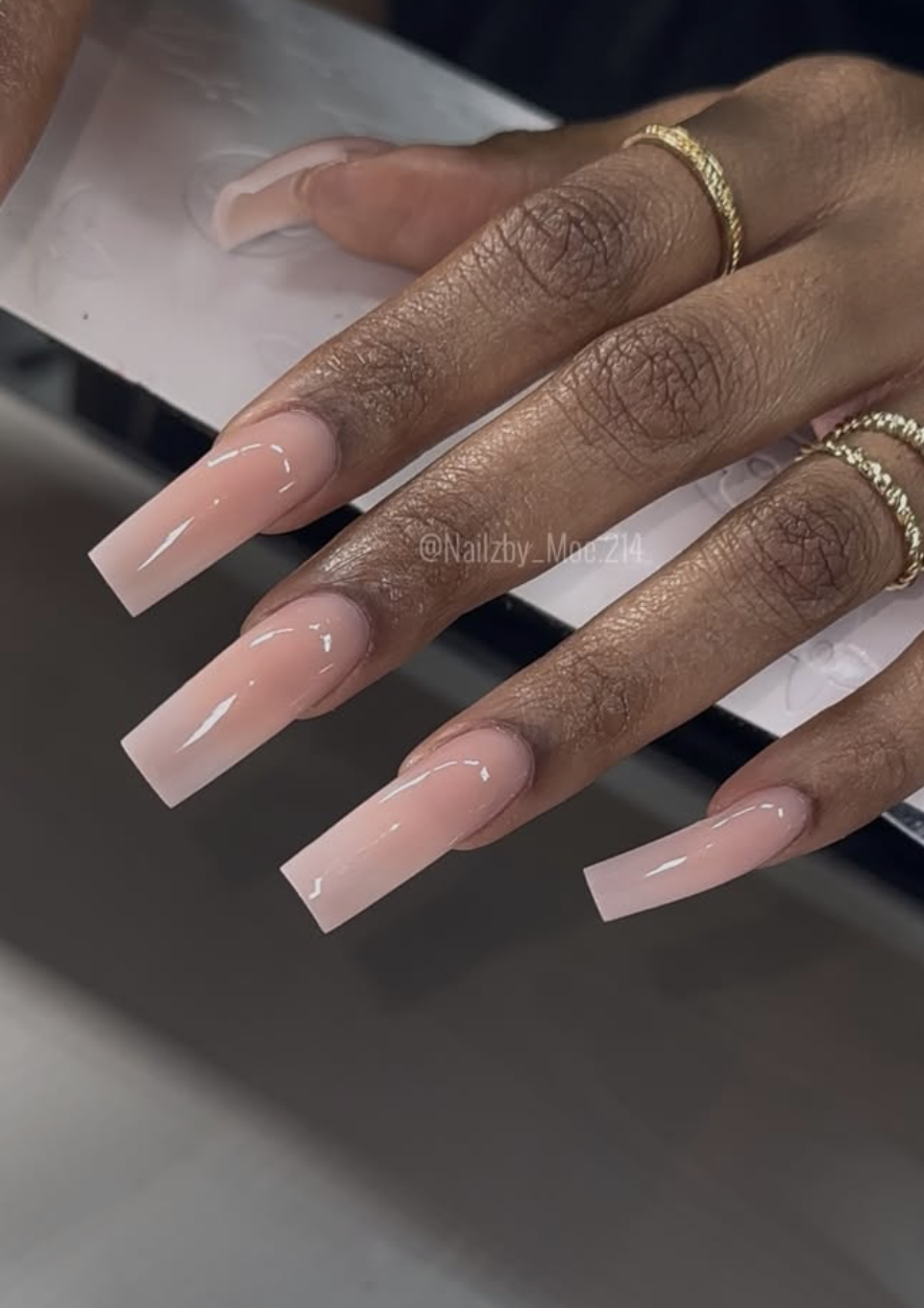 Long square-shaped nails with an ultra-glossy, semi-sheer milky nude polish, showcasing clean and cute June nail ideas.