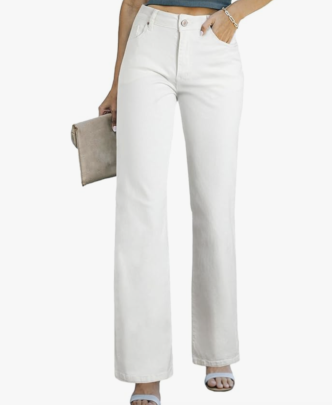 A woman wearing high-waisted white straight-leg jeans styled with light blue heeled sandals and a neutral clutch.