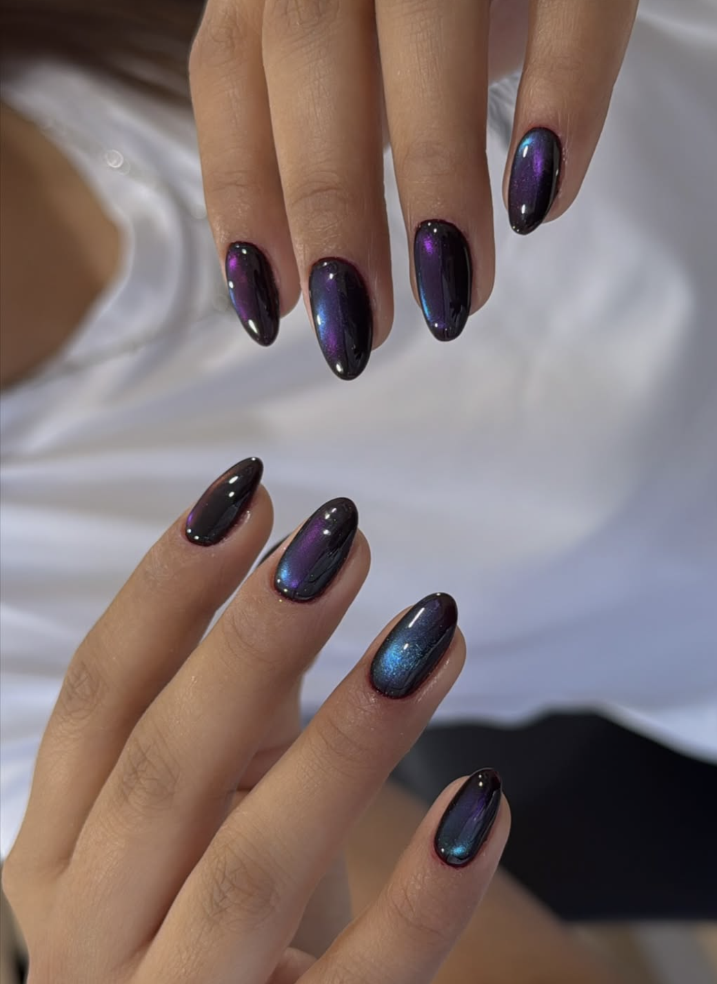 Midnight-blue and plum aura manicure on almond nails.