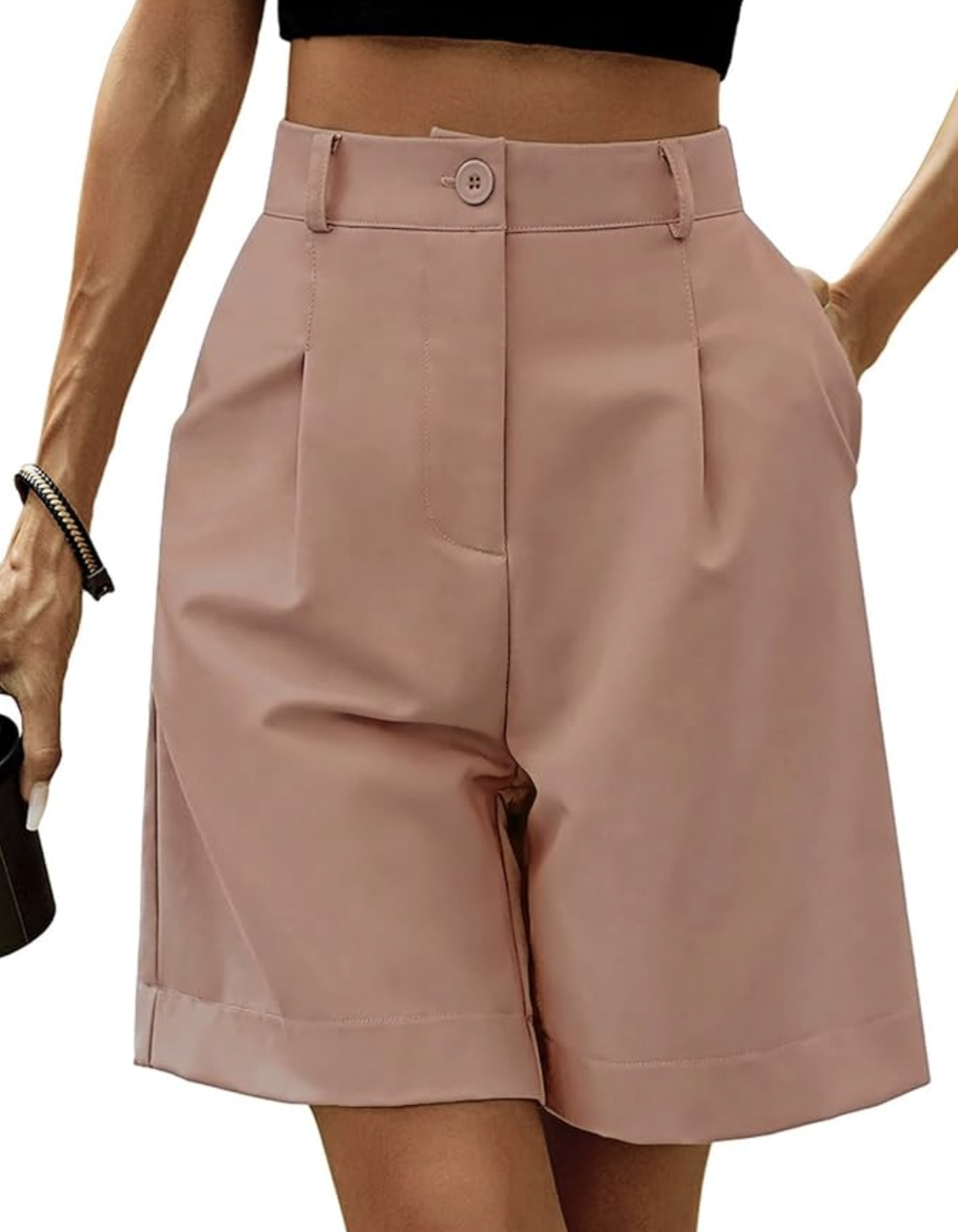 A close-up of a woman wearing light mauve pink tailored Bermuda shorts from Amazon with front pleats and a cuffed hem.