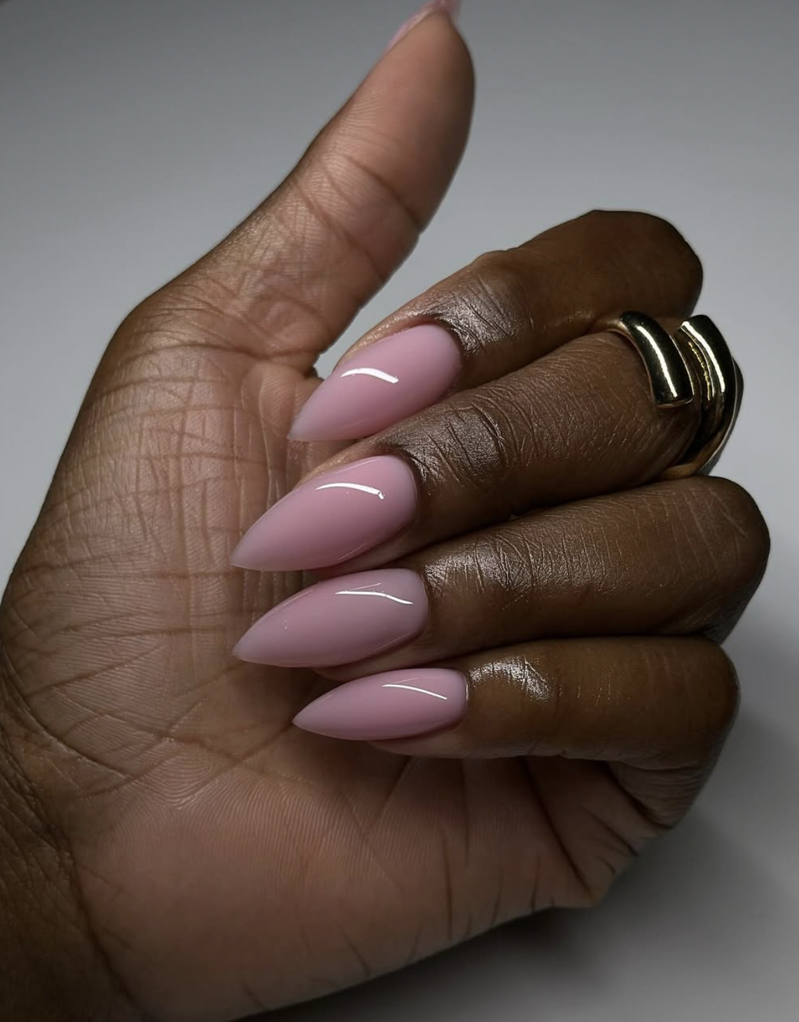 Glossy short nails painted a muted dusty clay pink shade.