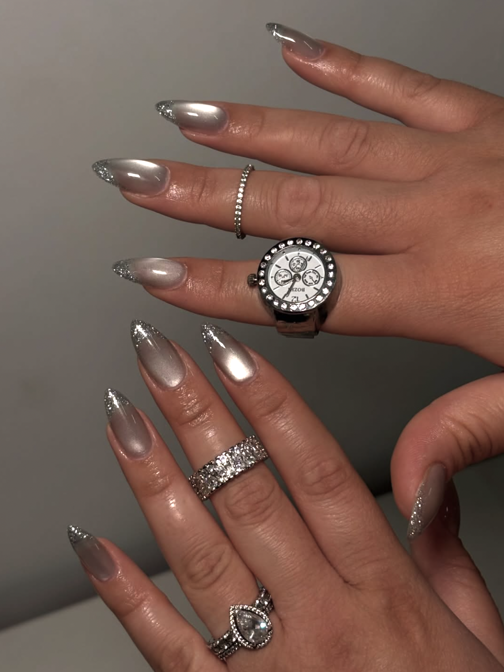 Long almond shaped nails with a neutral base and a shimmering silver chrome aura gradient in the center.