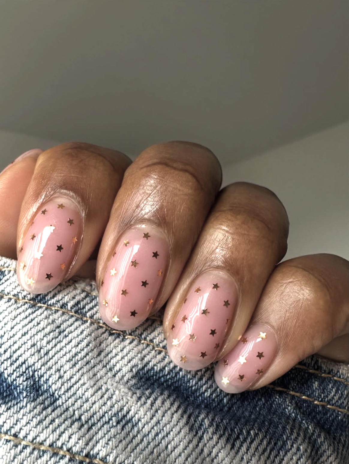 Short nude winter nails decorated with tiny gold stars