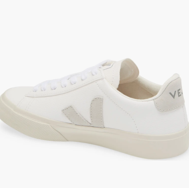 Side profile of the white Veja Campo sneakers featuring a light beige suede "V" logo and matching heel tab on a crisp white leather upper.