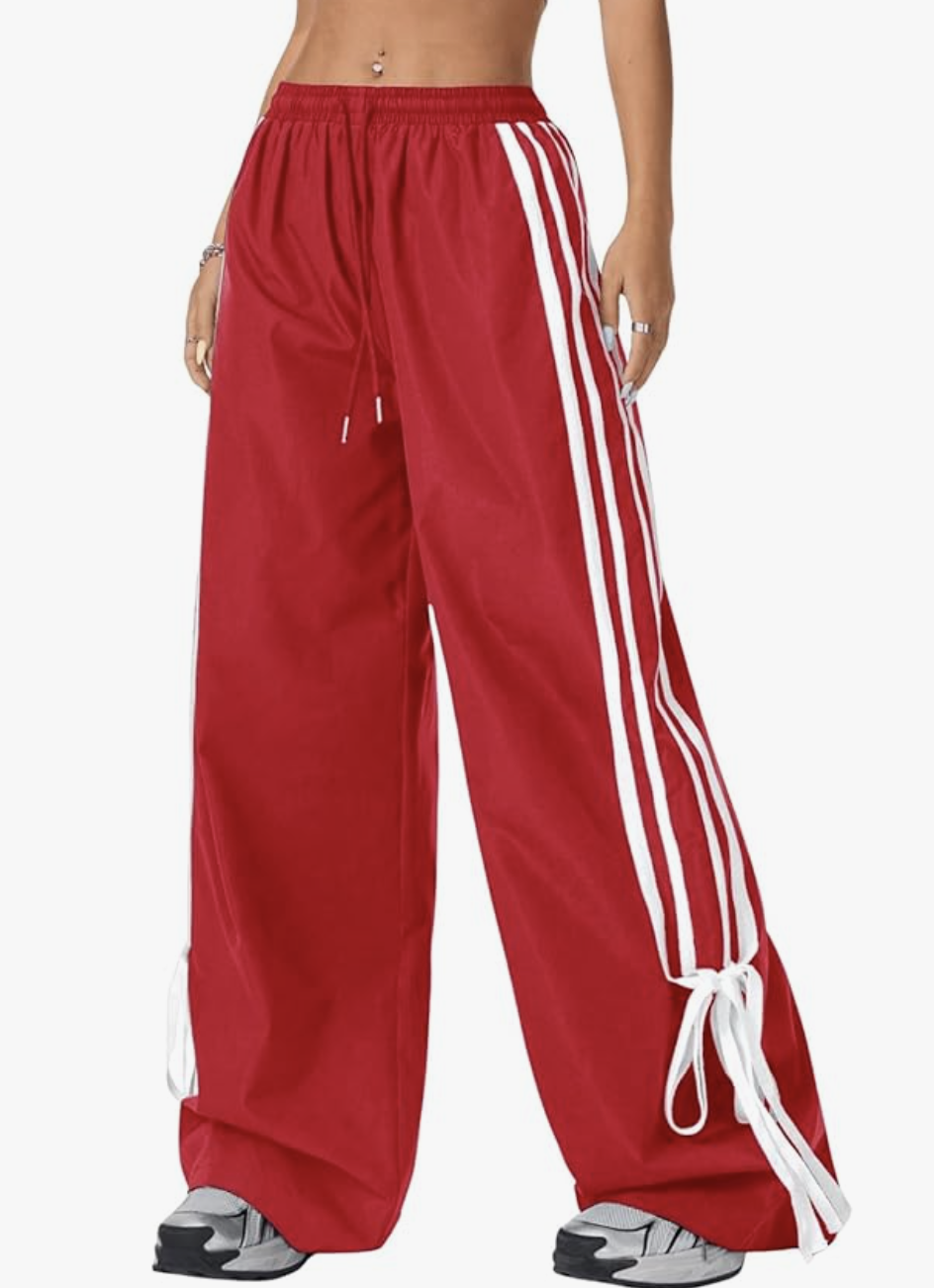 Affordable style hack: Amazon Bow Wide Leg Track Pants in vibrant red with white side stripes, featuring a high-waisted flowy silhouette and split hem detail for a high-low spring outfit.