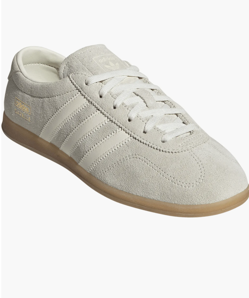 A pair of yellow adidas Gazelle Lo Pro sneakers with white stripes and a classic gum sole, styled for a casual dress outfit.