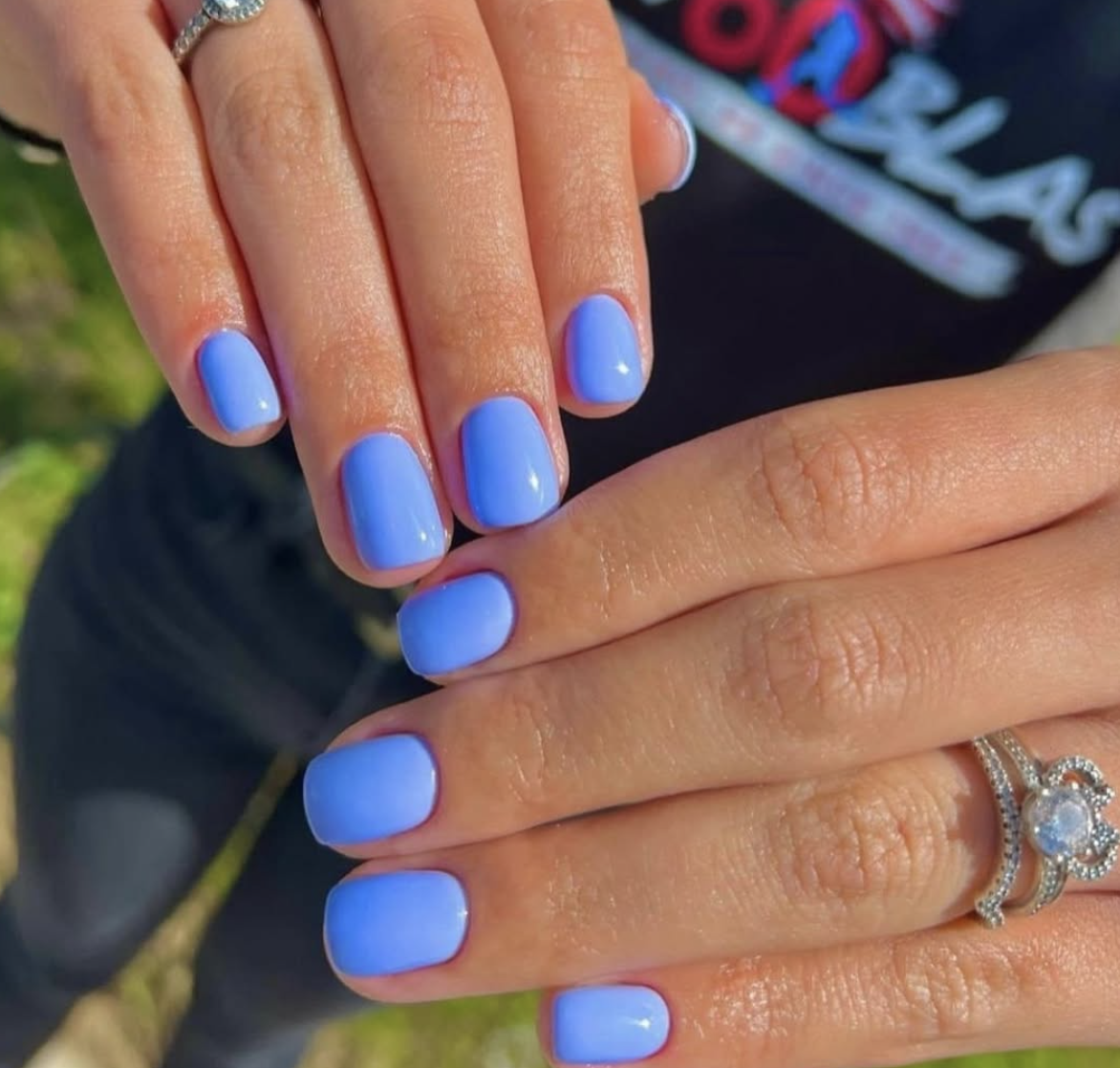 A short, square manicure in a creamy cornflower blue shade, representing a top summer 2026 nail colour.