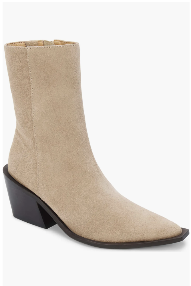 A side view of a beige suede ankle boot featuring a sharp pointed toe and a black stacked block heel.