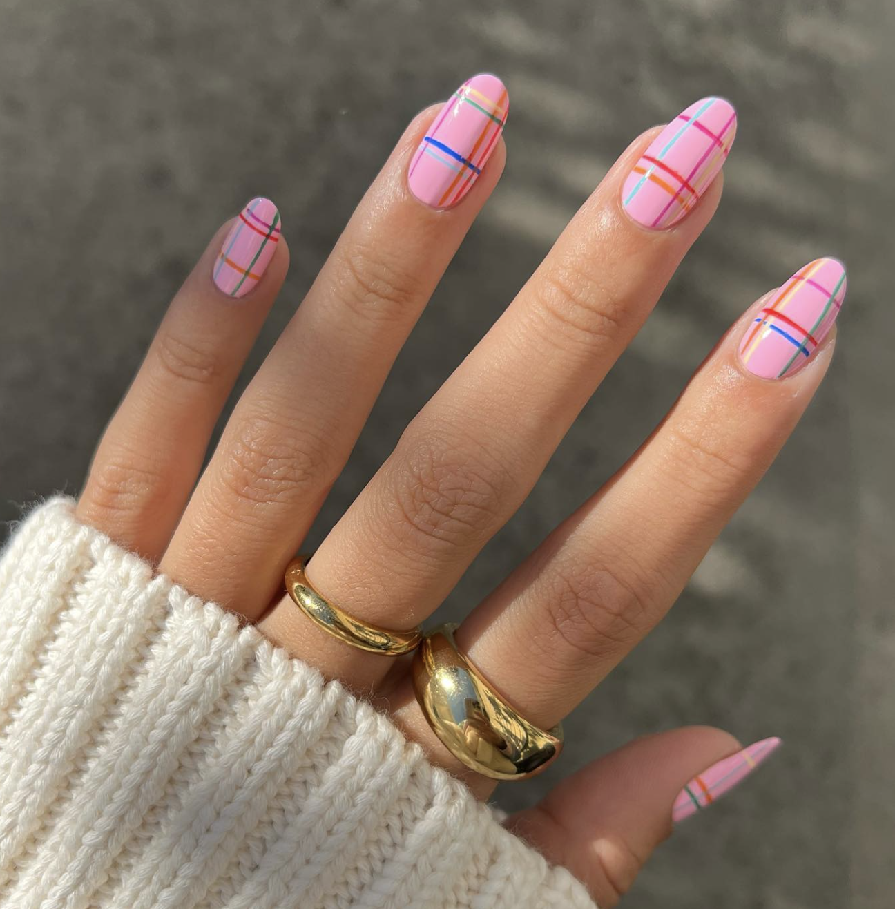 Short taupe nails with one fine burgundy, black and camel plaid accent.