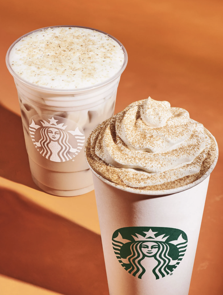 An iced fall coffee topped with foam beside a hot Starbucks drink finished with whipped cream and cinnamon.