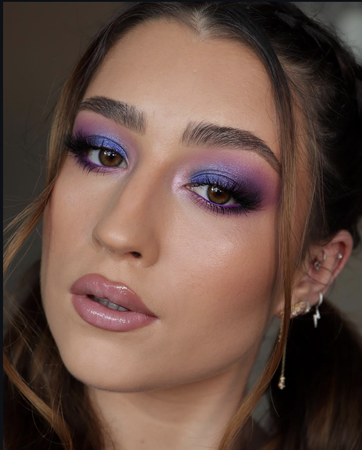 Woman wearing blended plum eyeshadow and a complementary nude lip