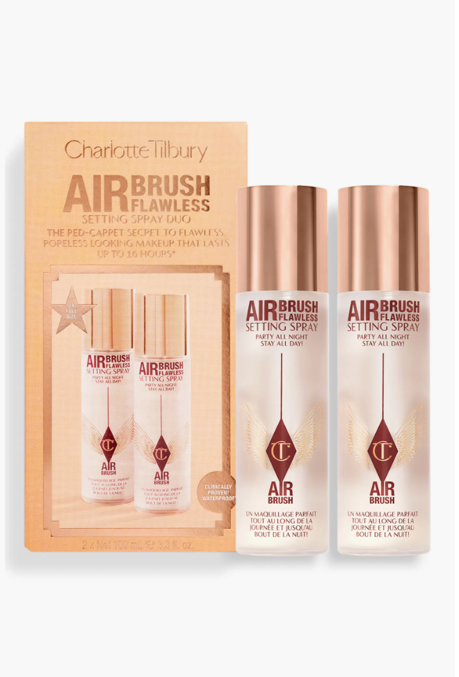 A close-up of the Charlotte Tilbury Airbrush Flawless Setting Spray Duo packaging and two metallic pink and white spray bottles, a featured beauty pick.