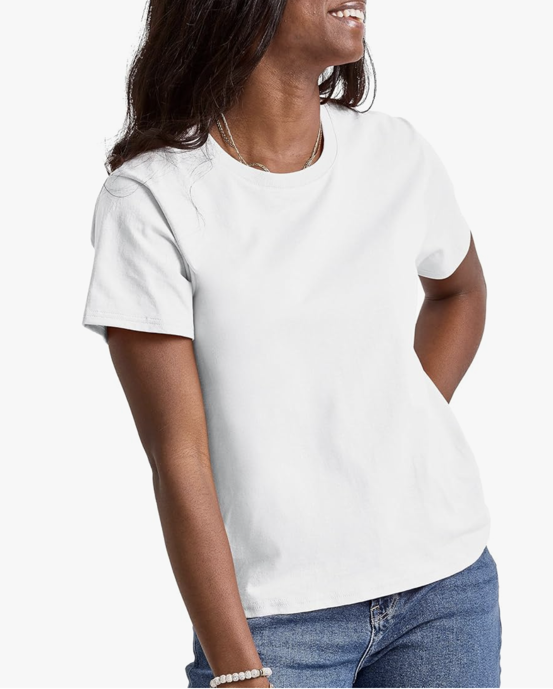 A Black woman wearing a crisp white Hanes Essentials cotton crewneck t-shirt tucked into blue jeans, demonstrating a non-see-through and high-quality wardrobe basic.