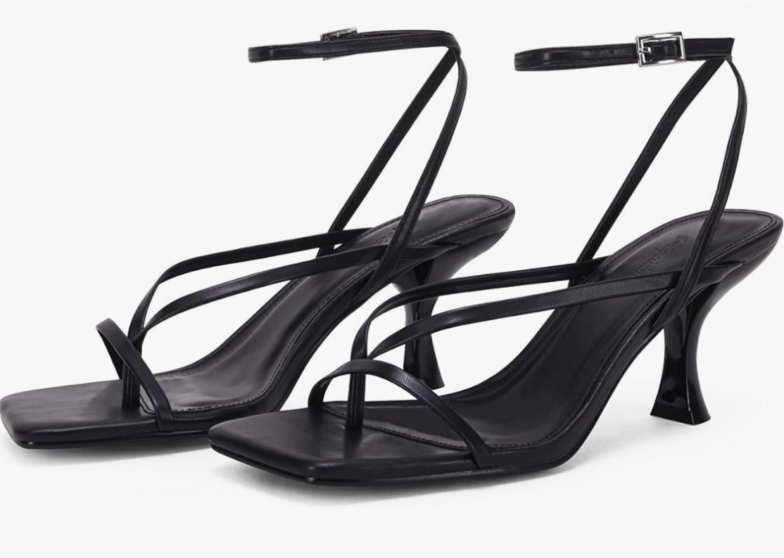 A pair of black strappy high-heeled sandals with a modern square toe and thin laces, styled for a formal wrap dress look.