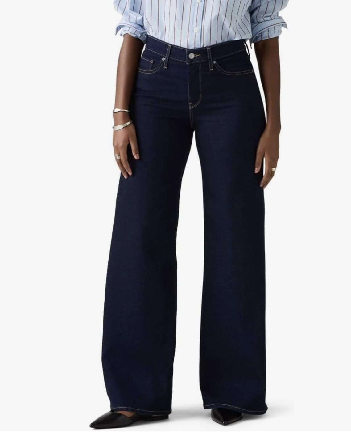 A close-up of a woman wearing Amazon high-waisted wide-leg jeans in a dark-wash denim, styled with a light blue striped button-down shirt tucked in.