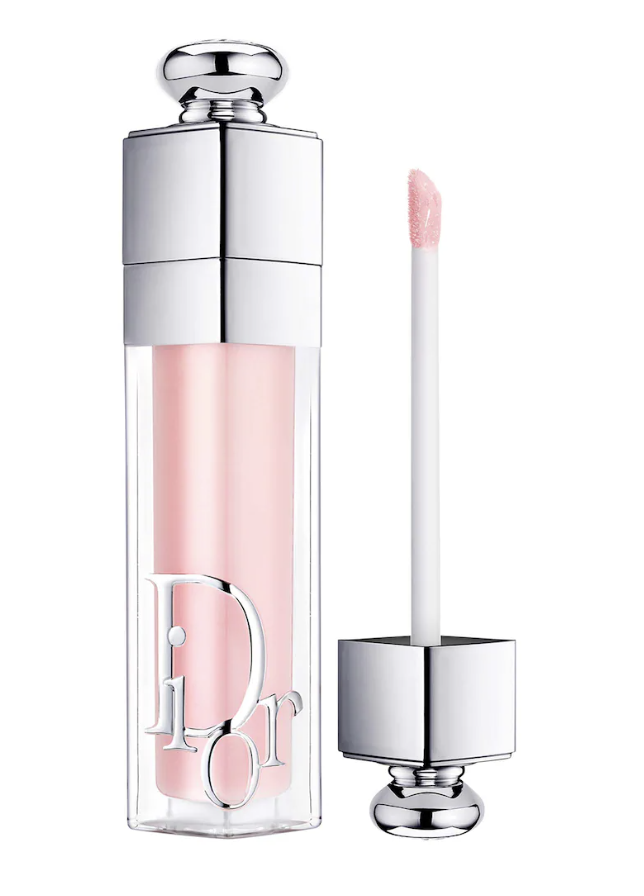 A tube of Dior Addict Lip Maximizer gloss in the classic pale pink shade 001, featuring its signature silver logomania typography and soft sponge applicator.