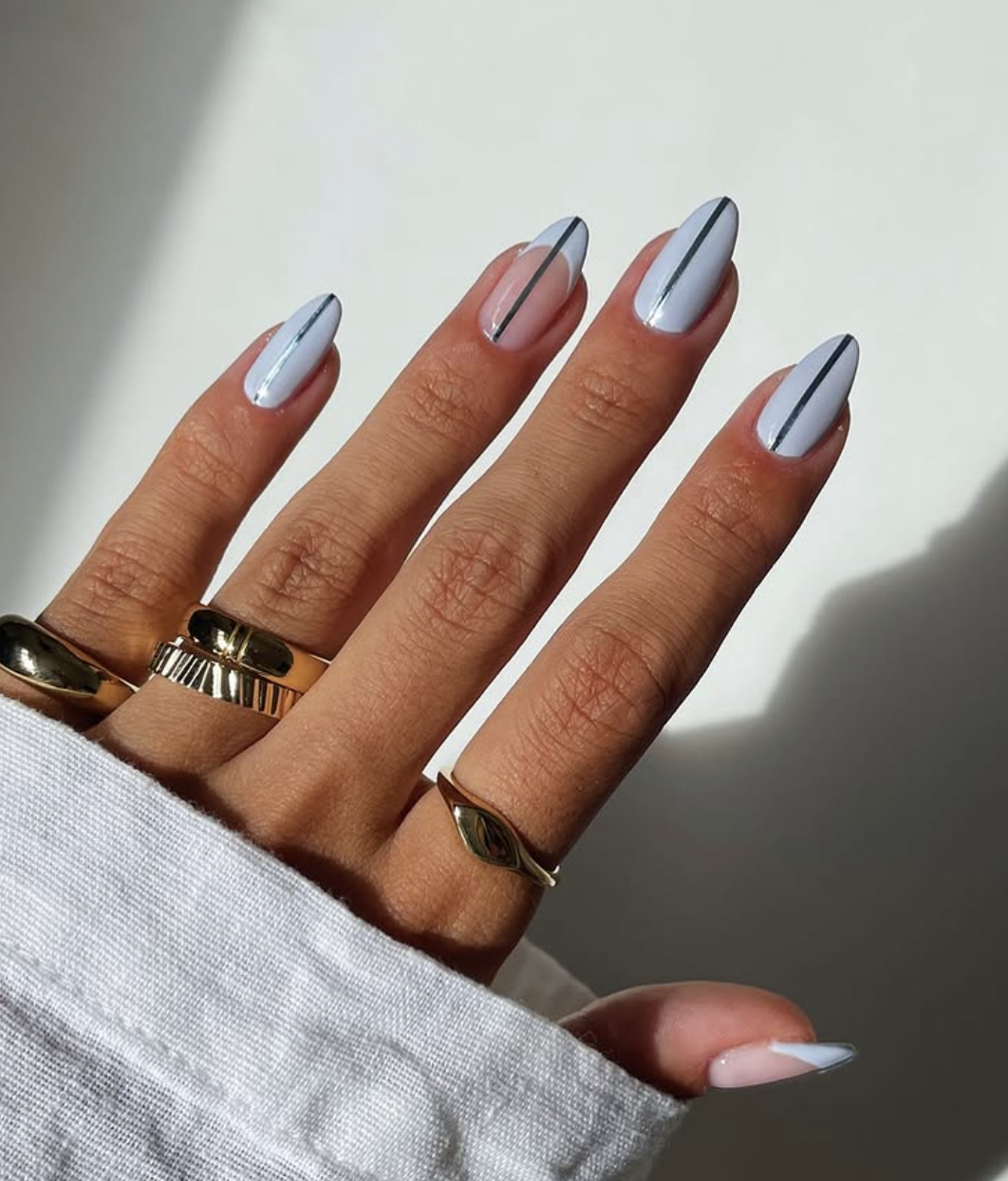 Long almond-shaped nails with a glossy pale baby blue base featuring a crisp, minimalist vertical black line down the center of each nail.