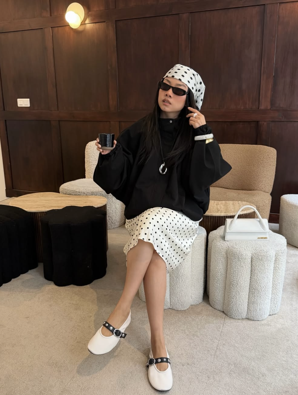 woman styling polka dots as accessories — black and white polka dot headscarf and skirt with an all-black outfit