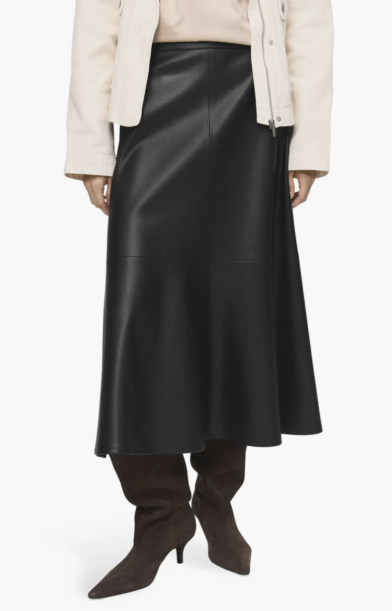 A studio product shot of the MANGO Paris Faux Leather A-Line Midi Skirt in black, featuring an elegant A-line silhouette and a smooth leather-like finish, styled with black boots.