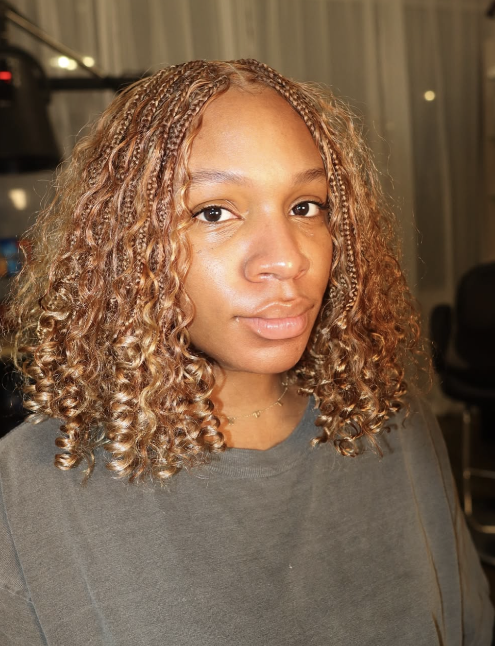 Woman wearing a blunt shoulder-skimming braided bob in a deep smoked-espresso brown.