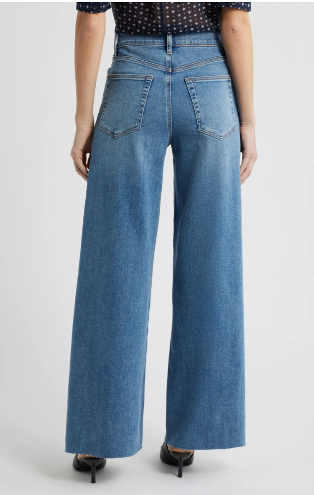 Rear view of FRAME Le High Flare jeans showing the sleek fit through the thigh and dramatic kick-flare hem that balances a flat bottom and hip dips.