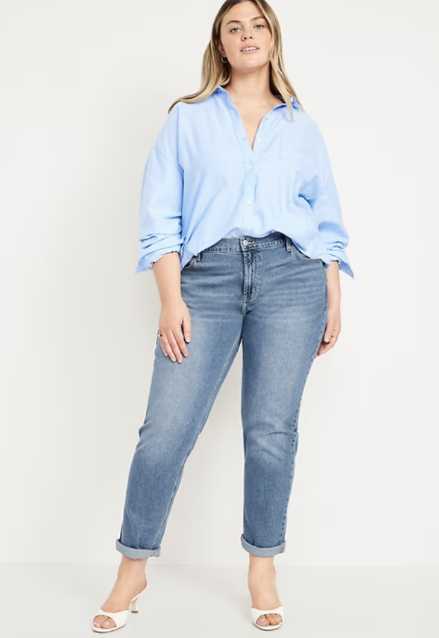 Woman wearing Old Navy mid-rise wow boyfriend straight jeans in a medium wash, styled with rolled cuffs for a petite fit.