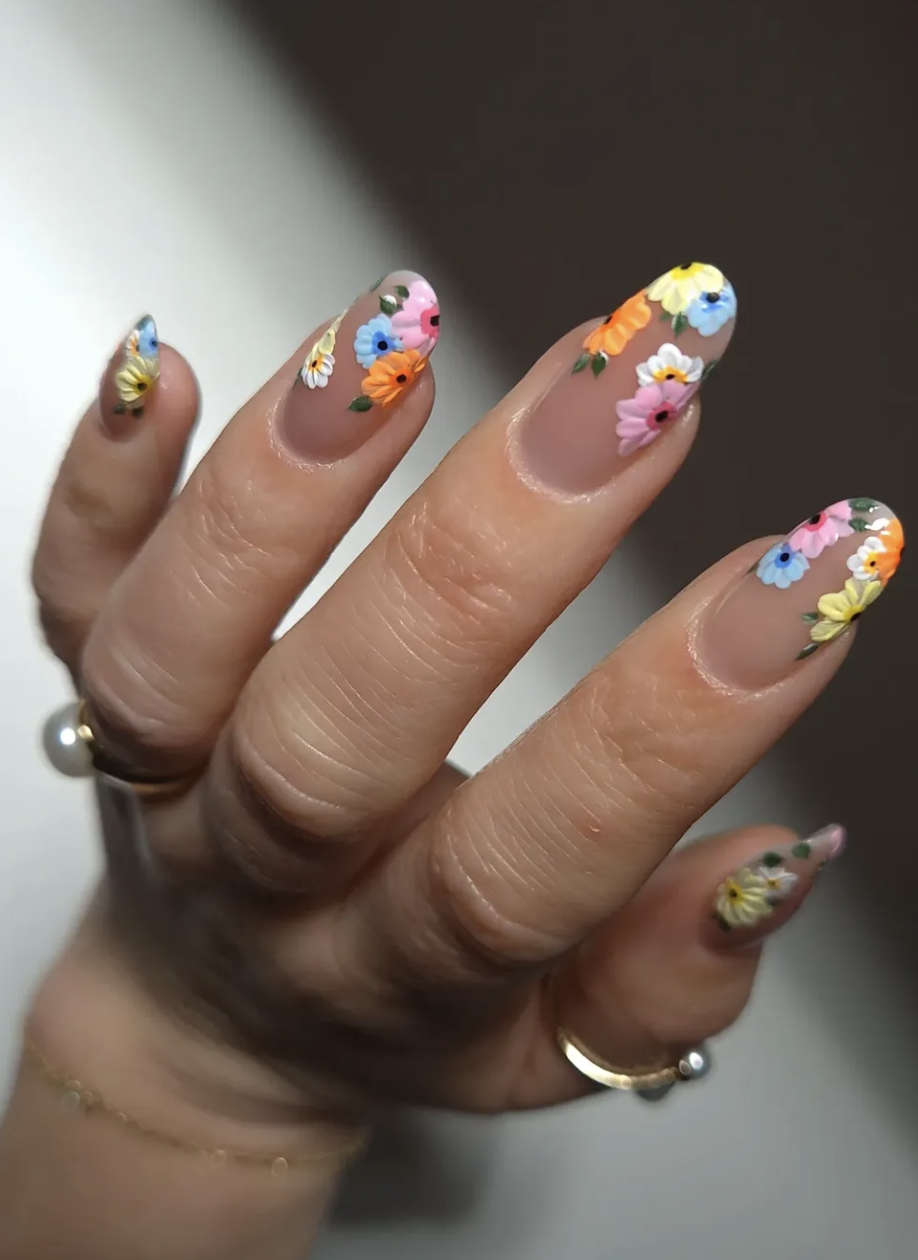 A high-feminine spring manicure by @rebekahxpritchard featuring dark, glossy almond nails adorned with delicate hand-painted white and yellow daisies.
