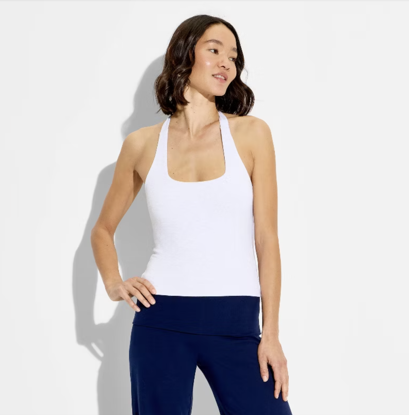 A woman wearing a white Wild Fable lace halter top from Target, styled with dark blue trousers for a clean Spring 2026 look.