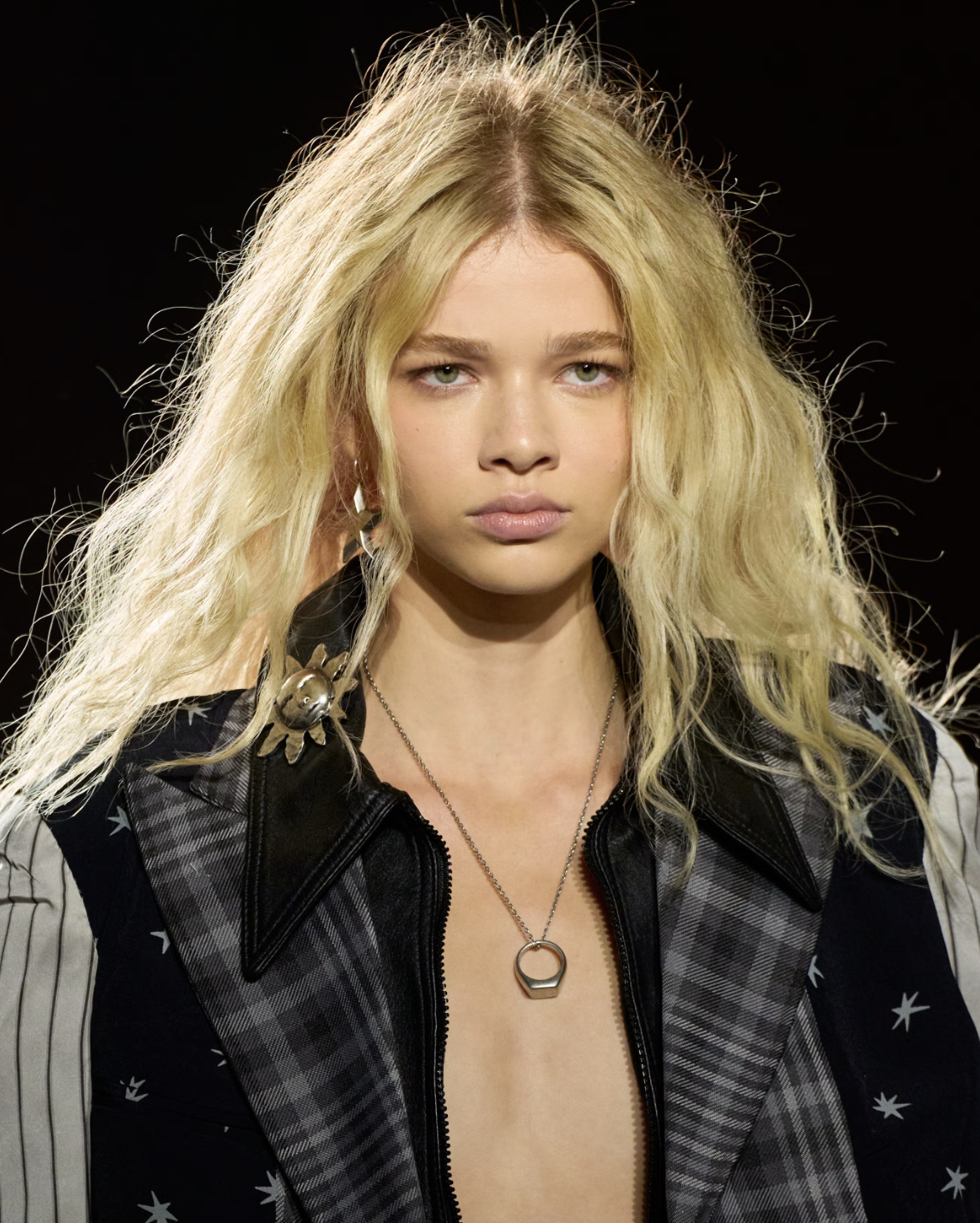 Blonde model at the Coach Fall/Winter 2026 show featuring 'Sleepy-Girl' bedhead hair and smudged eyeliner, a top 2026 beauty trend.