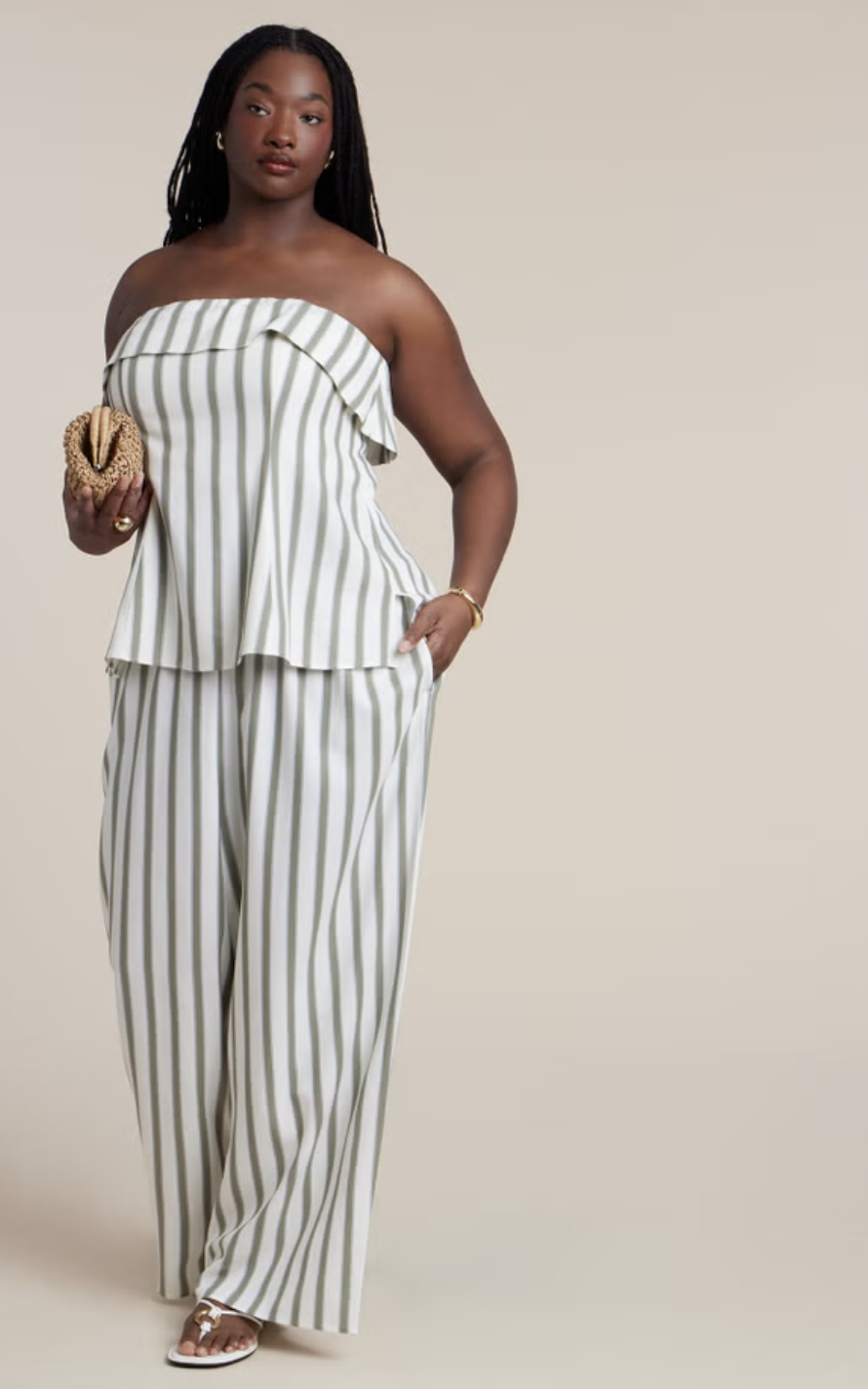 Plus-size woman wearing a matching green and white striped strapless top with ruffles and matching wide-leg pants.