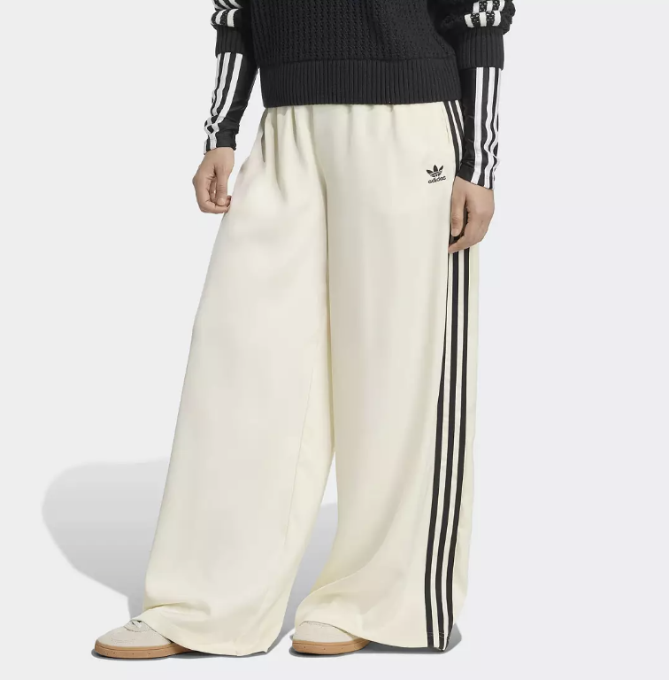 A side view of the adidas Originals Adicolor Satin Wide Leg Track Pants in Wonder White, featuring a high-waisted fit, flowing satin fabric, and iconic black side stripes for a clean, minimalist spring look.